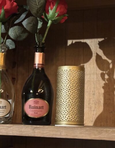 Twee flessen Ruinart champagne met een rode roos